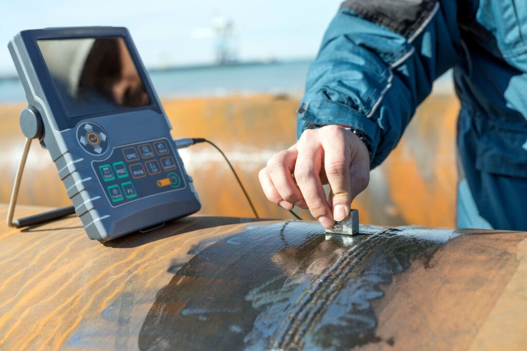 Inspector is testing with digital ultrasonic device to weld of pipe material in construction site.